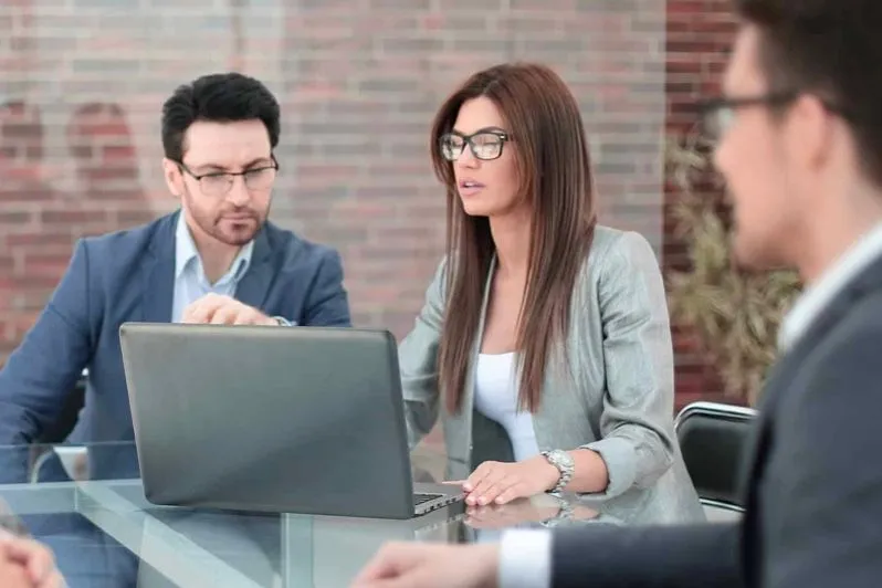 Bankberater besprechen sich an einem Laptop