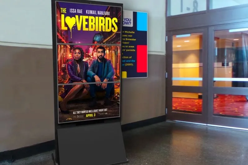 Bildschirm mit einem digitalen Filmplakat in einem Kinoflur