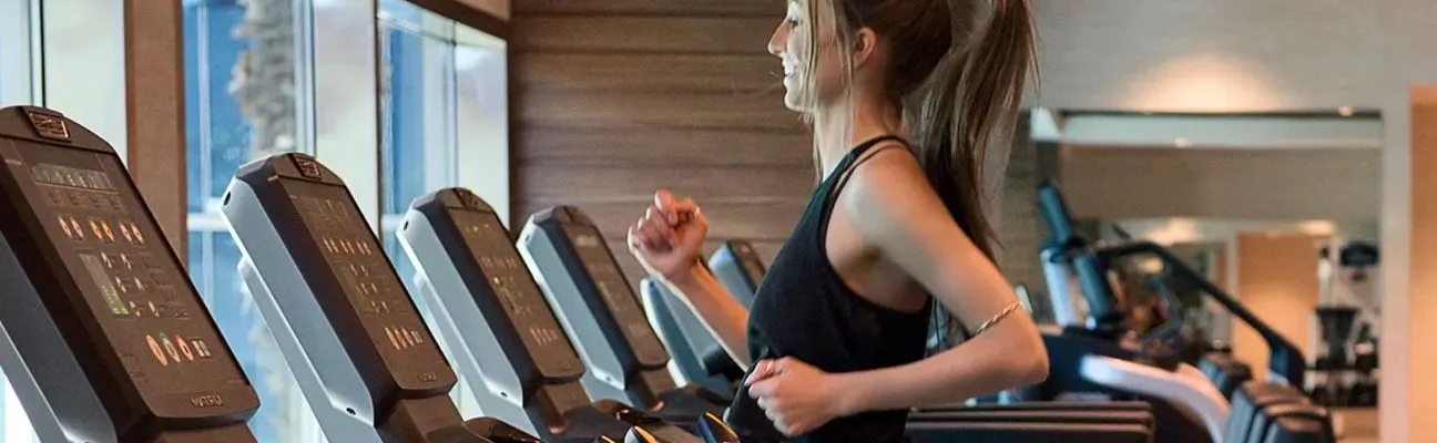Menschen laufen auf Laufbändern in einem Fitnessstudio