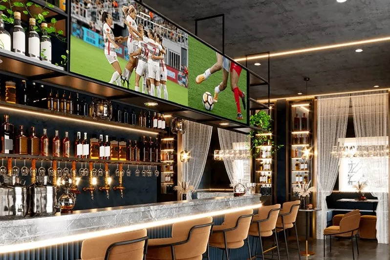 Bar mit Bildschirmen, die über den Flaschen Sport zeigen