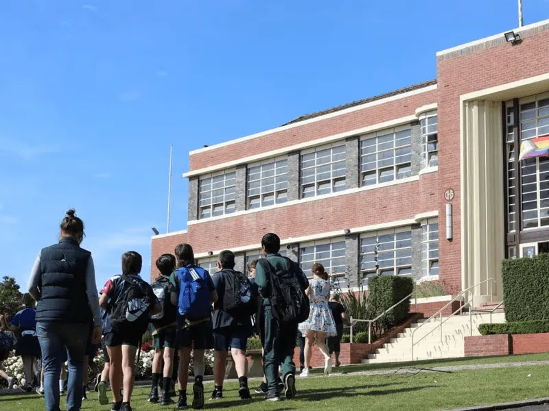 Schülerinnen und Schüler auf dem Weg zu einem Schulgebäude